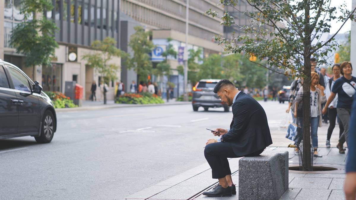 A person stressed at work looking overwhelmed by devices