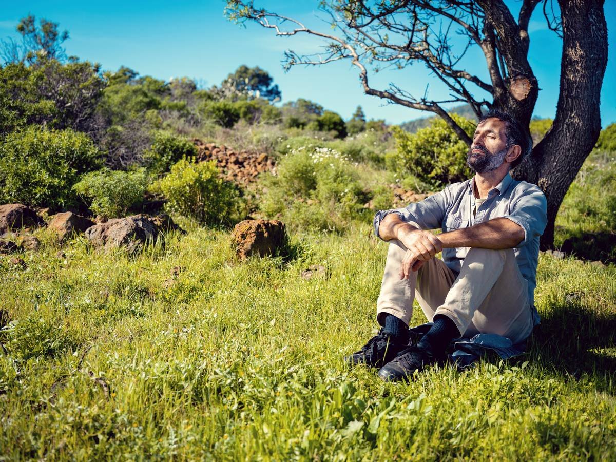 A person meditating at their desk with headphones