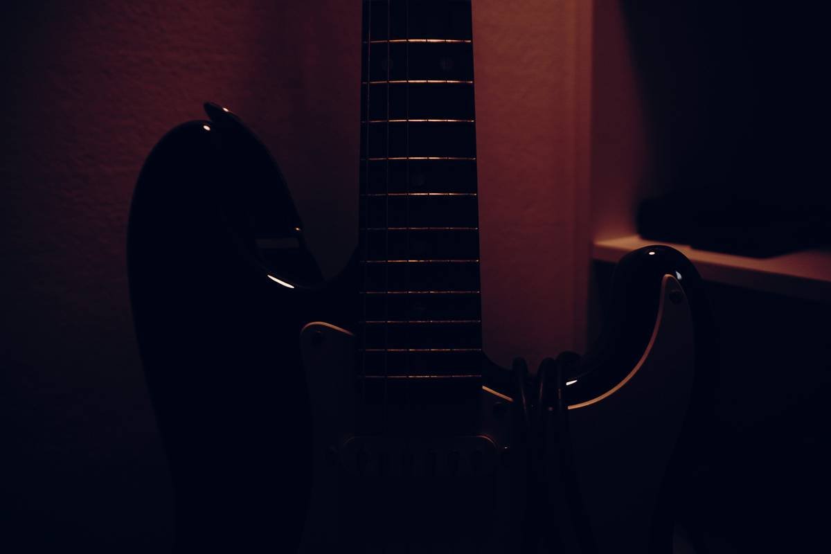 A woman sitting cross-legged meditating under a sunset sky.